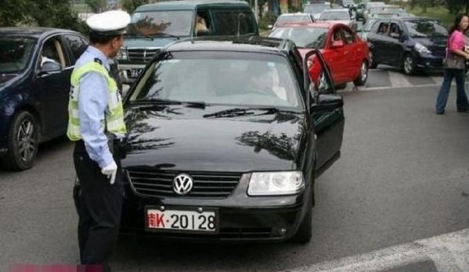 Китайский полицейский останавливает поток машин